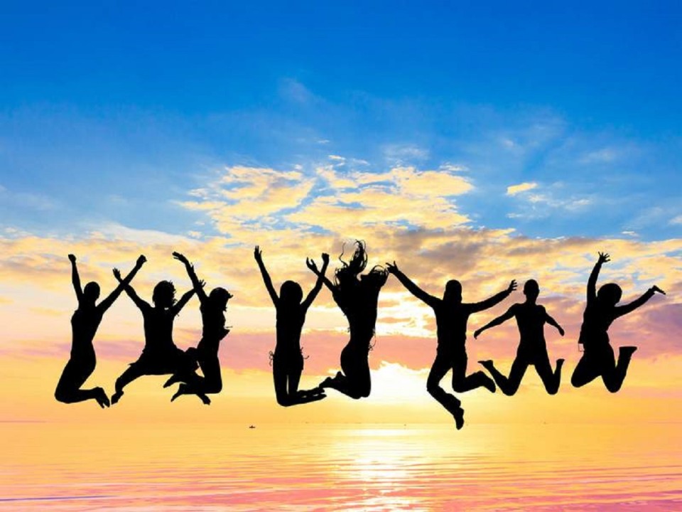 silhouette of a group of people jumping in the air in front of a sunrise